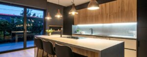Cucina moderna con isola centrale, piano snack e pensili in legno.